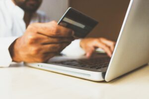 image of man using credit card to purchase something on his laptop